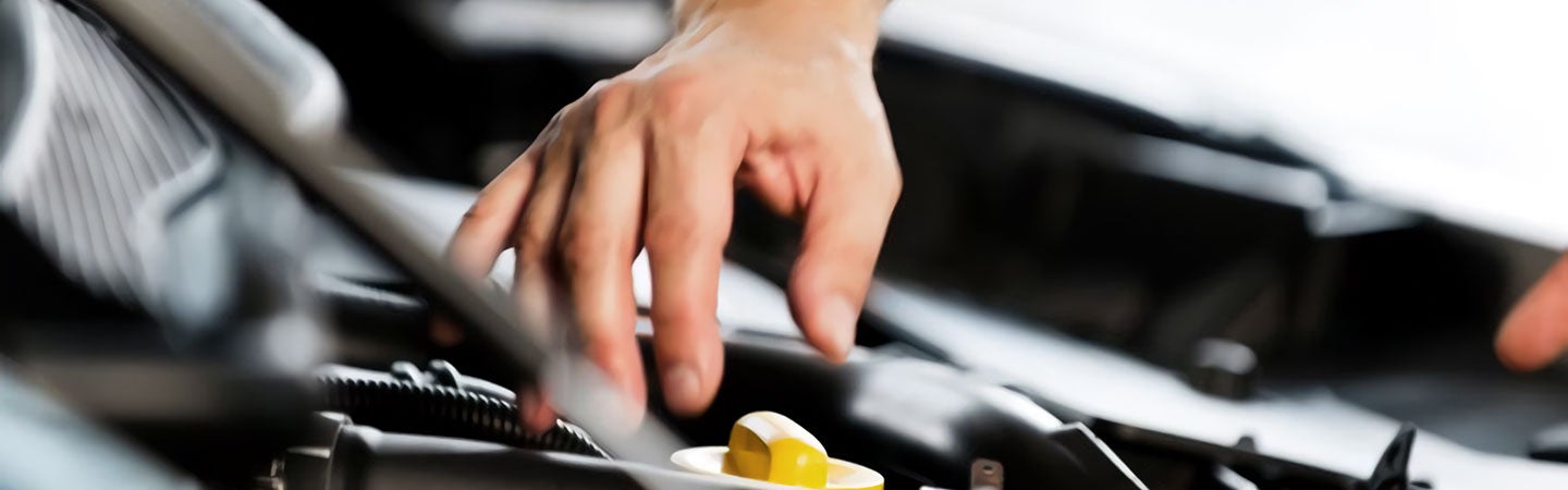 Close up of mechanic's hand examining a vehicle engine