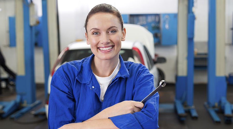 Smiling mechanic holding a wrench